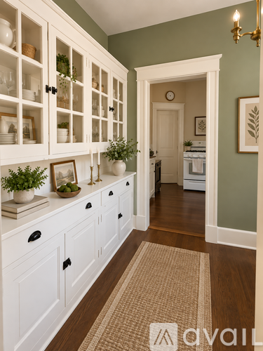 A kitchen with white cabinets and a rug on the floor.