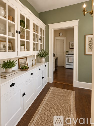 A kitchen with white cabinets and a rug on the floor.
