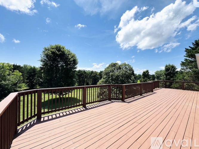 A wooden deck with a railing and trees in the background.