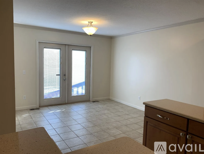 A room with a tiled floor and a sliding glass door leading outside.