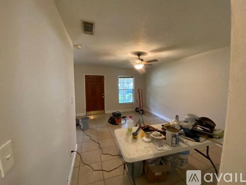 A room with a table and a fan on the ceiling.
