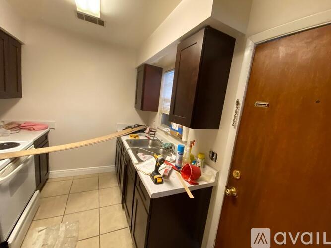 A kitchen with brown cabinets and a wooden door.