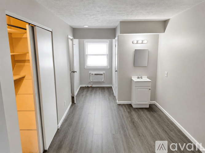 A long hallway with a white cabinet and a window.