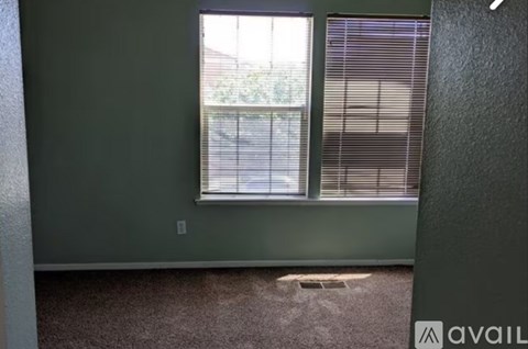A room with a window and a carpeted floor.