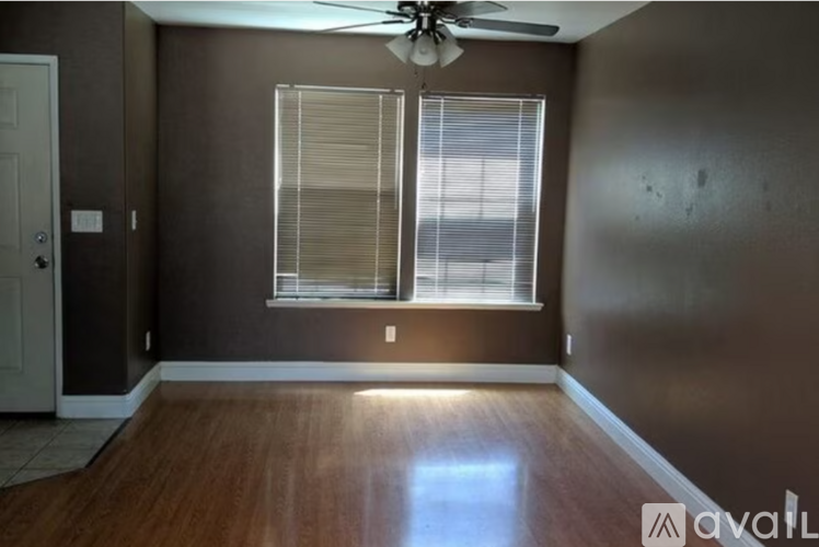 A room with a ceiling fan and a window with blinds.