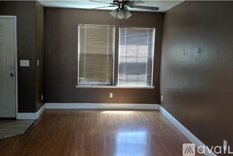 A room with a ceiling fan and a window with blinds.