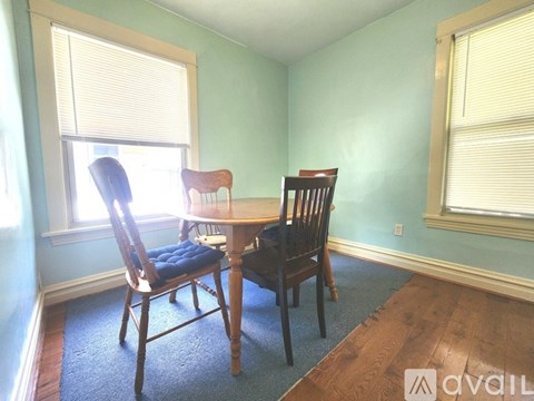 A dining room with a table and two chairs.