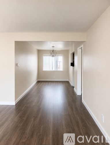 A room with wooden floors and a chandelier.