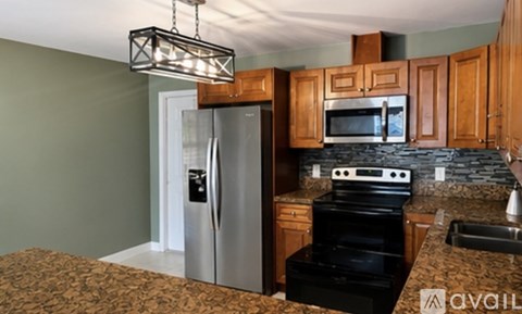 A kitchen with granite countertops and stainless steel appliances.