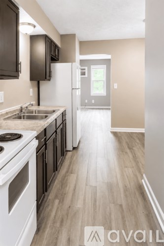 A kitchen with white appliances and wooden floors.