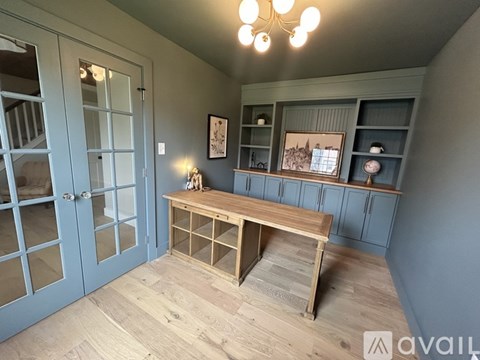 A room with a wooden table and a blue door.