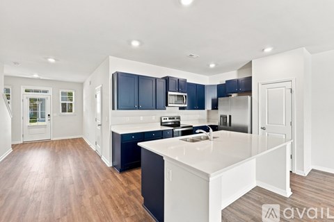 A modern kitchen with dark blue cabinets and a white island.