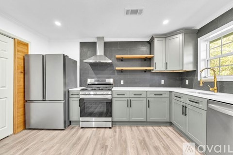 A modern kitchen with a stainless steel refrigerator and oven.