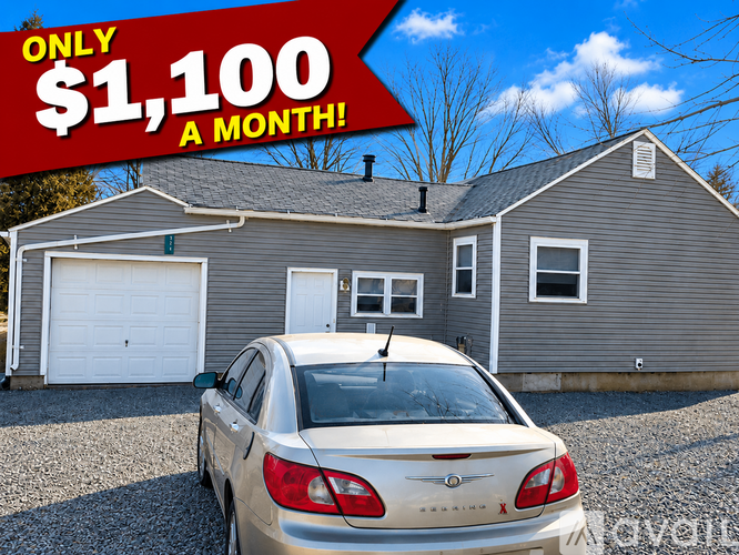 A car is parked in front of a house with a sign that says "ONLY $1,100 A MONTH!".