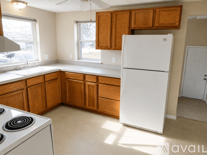 A kitchen with a white fridge and wooden cabinets.
