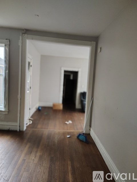 A hallway with a wooden floor and white walls.