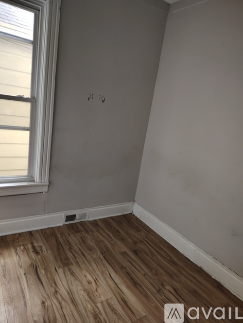A room with wooden flooring and a window.