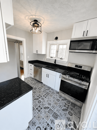 A kitchen with black countertops and white cabinets.