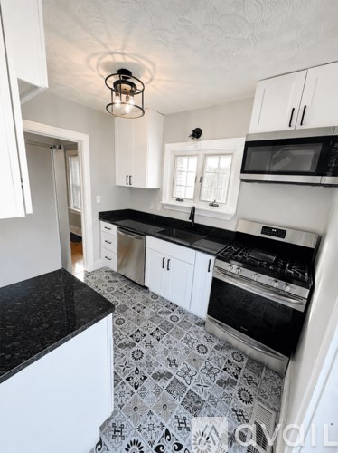 A kitchen with black countertops and white cabinets.