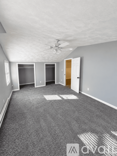 A room with grey carpet and white walls.