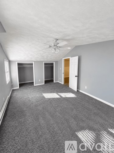 A room with grey carpet and white walls.