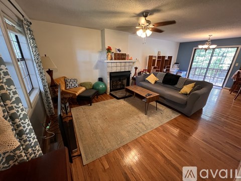 A living room with a grey couch and a fireplace.