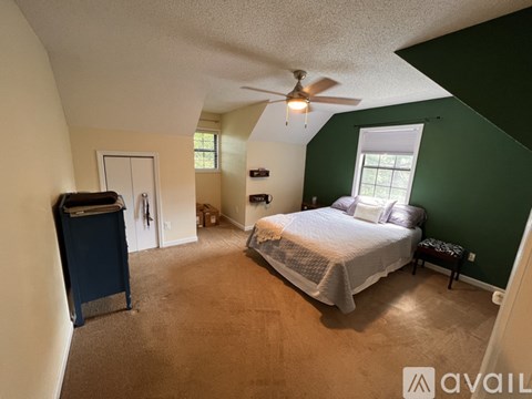 A bedroom with a bed, dresser, and window.