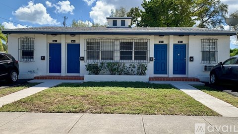 A white house with blue doors and windows is for sale.