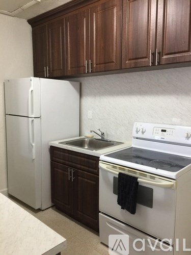A kitchen with brown cabinets and white appliances.
