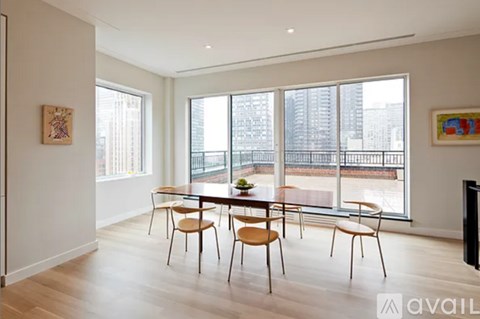 A dining room with a table and chairs and a view of a city.