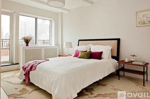 A bedroom with a large bed and a balcony overlooking the city.