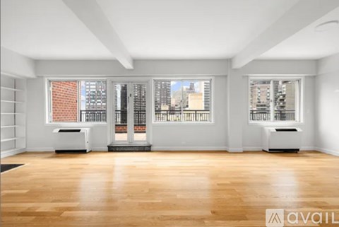 A spacious room with wooden floors and white walls.
