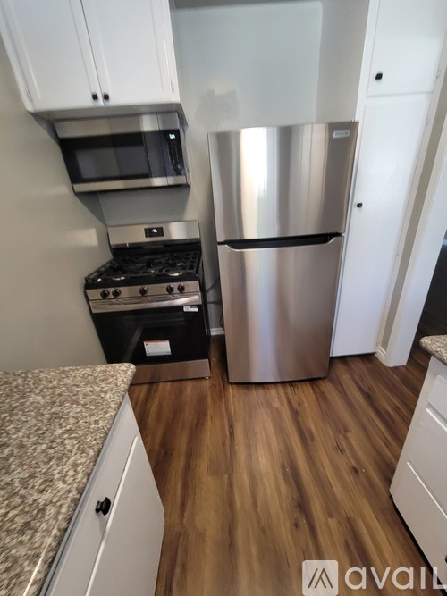 A kitchen with a stainless steel refrigerator and a microwave above the stove.