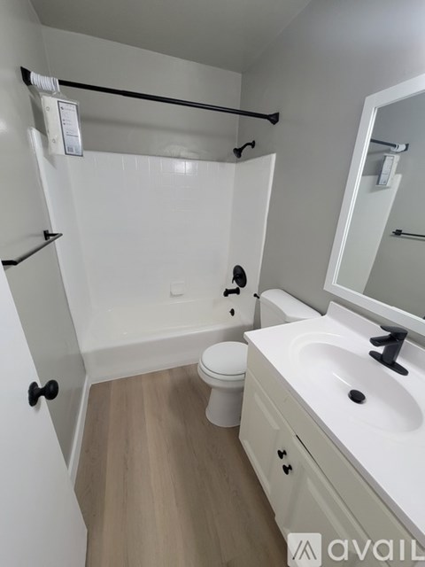 A bathroom with a white sink, toilet, and bathtub.
