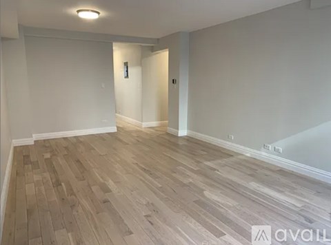 A room with wooden flooring and white walls.