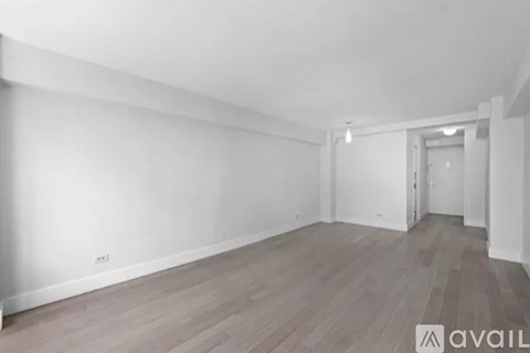 A room with wooden flooring and white walls.