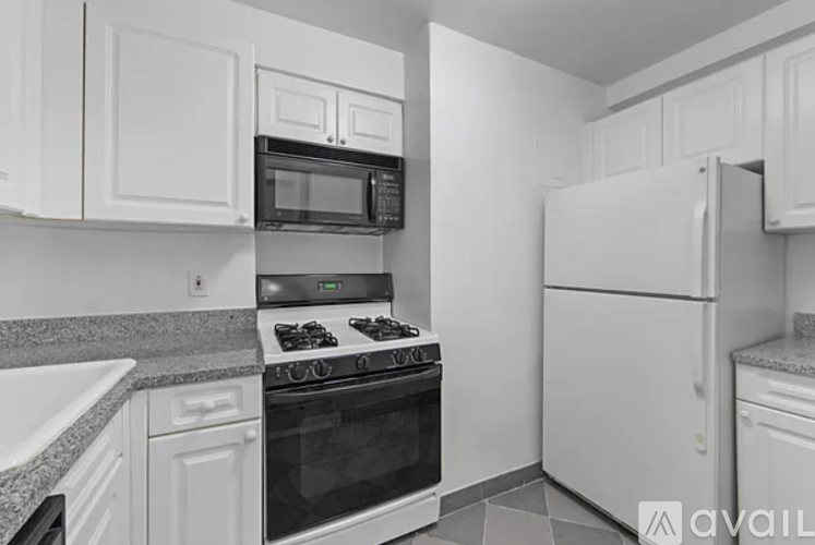 A kitchen with white cabinets and appliances.