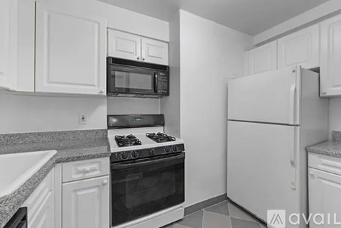 A kitchen with white cabinets and appliances.