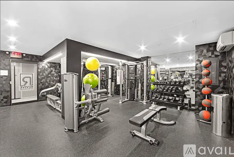 A gym with a variety of equipment including a bench, weights, and a squat rack.