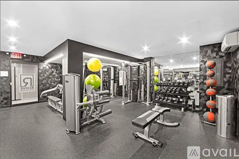A gym with a variety of equipment including a bench, weights, and a squat rack.