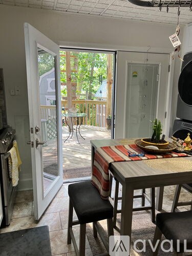 A dining room with a table set for two and a view of a deck outside.