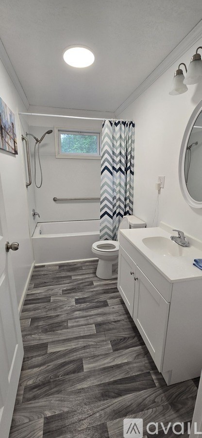 A bathroom with a toilet, sink, and shower.