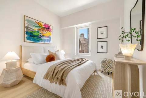 A bedroom with a large bed and a painting on the wall.