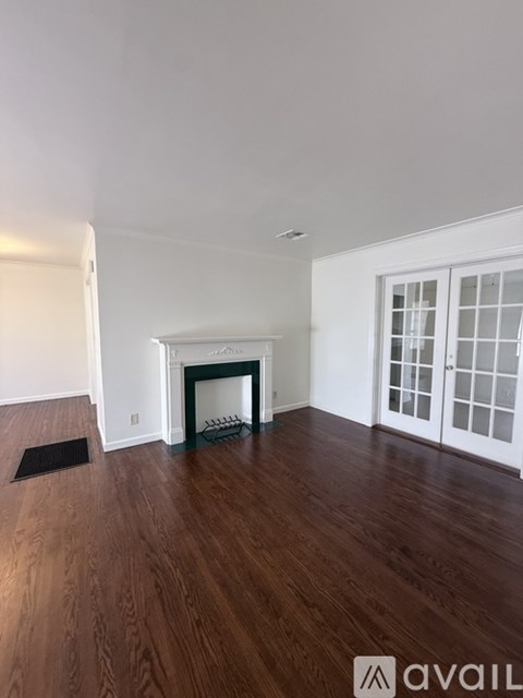A room with a fireplace and wooden floors.