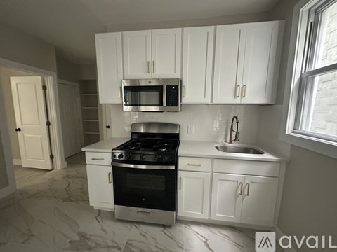 A kitchen with white cabinets and a black stove top oven.
