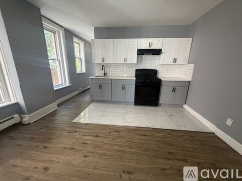 A kitchen with wooden floors and white cabinets.