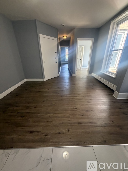 A room with wooden floors and grey walls.