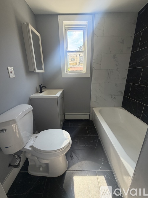 A white toilet sits next to a bathtub in a bathroom.