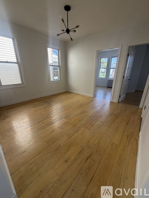 A room with wooden flooring and a ceiling fan.