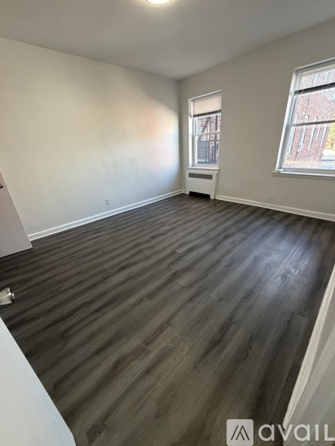 A room with wooden flooring and a window.